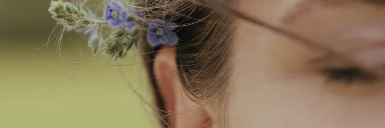 Closeup of a woman with lavender behind her ear