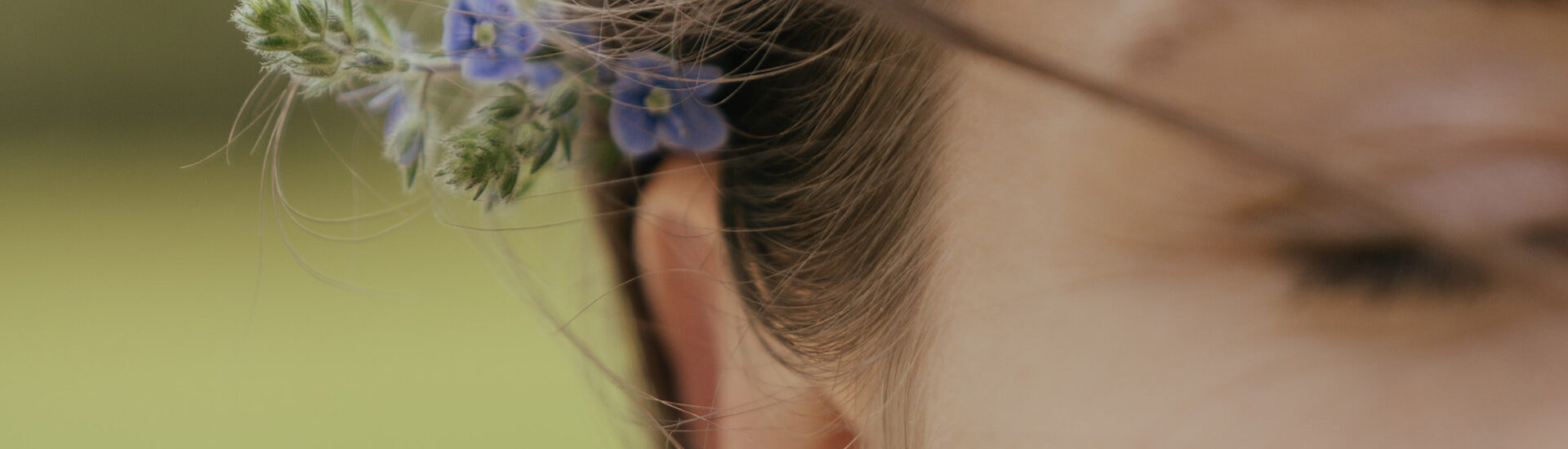 Closeup of a woman with lavender behind her ear